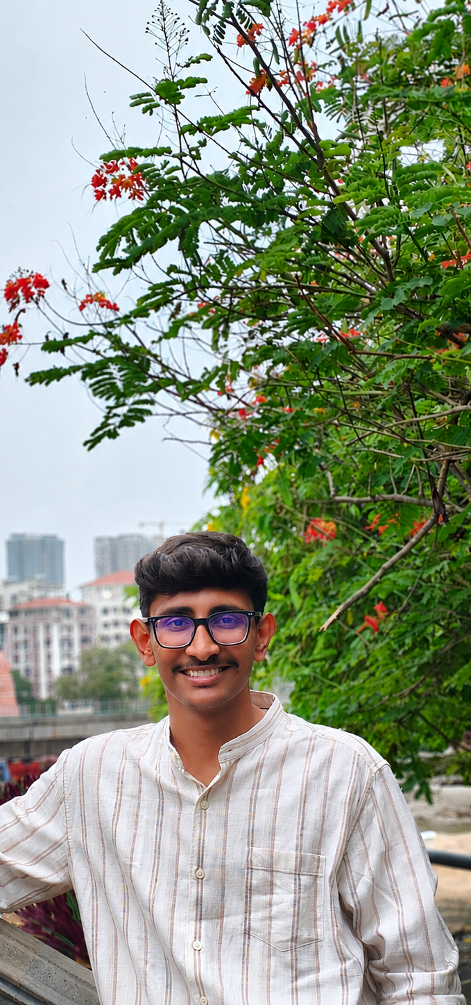 Uday Kumar G outdoors beneath flowering trees